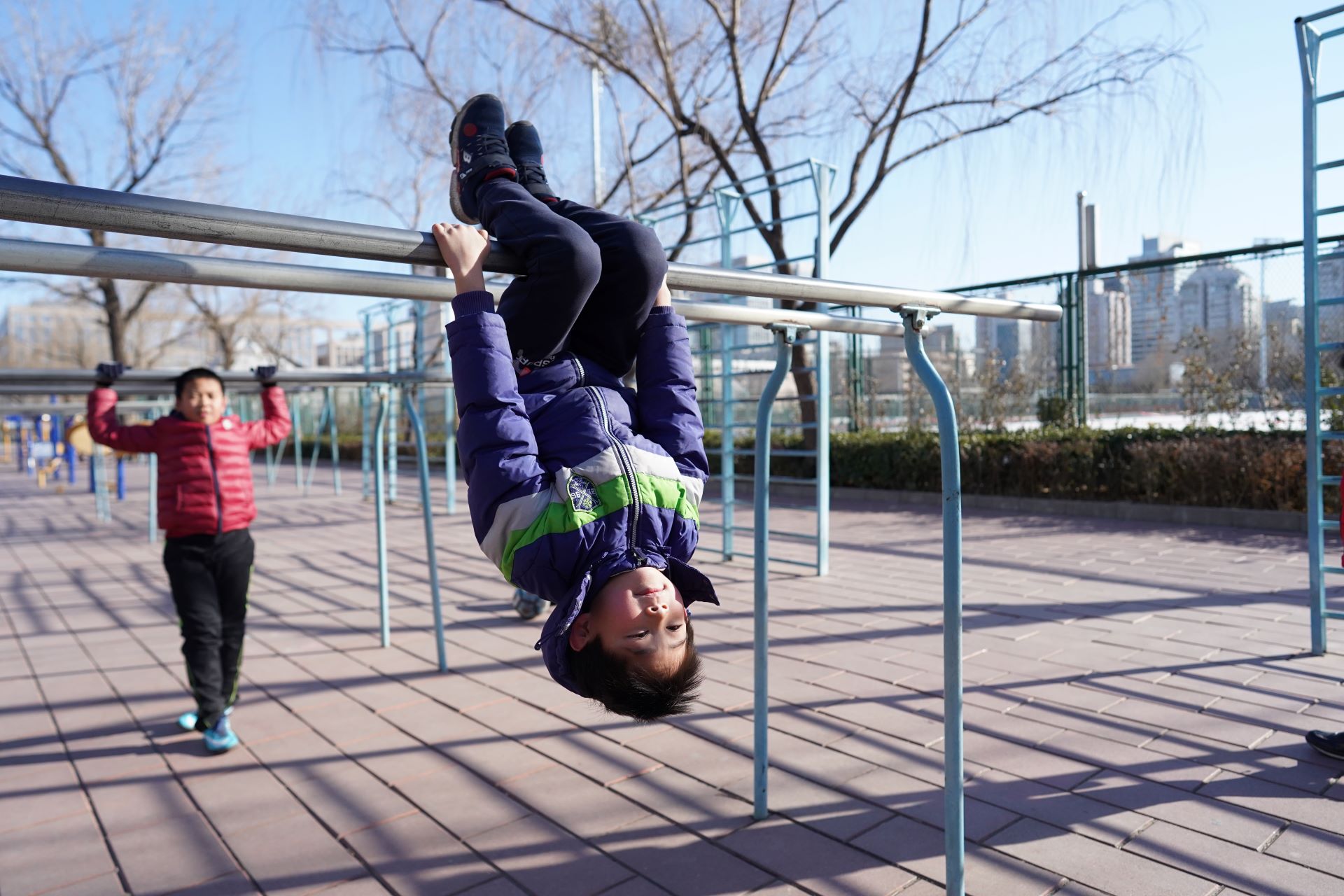 Boys using fitness equipment outside in Beijing